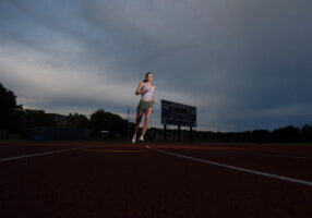 Senior runner portrait with strong dynamic lighting in Newton MA